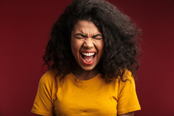 Image of disappointed african american woman with curly hair screaming