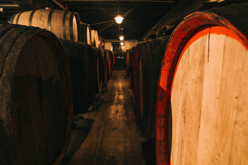 Wine in wooden barrels stored for aging in the cellar