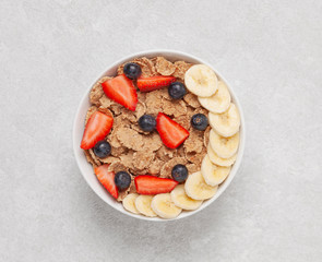 Multigrain wholewheat healthy cereals with banana and fresh berries blueberry, strawberry for breakfast. Top view 