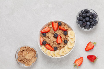 Multigrain wholewheat healthy cereals with banana and fresh berries blueberry, strawberry for breakfast. Top view 