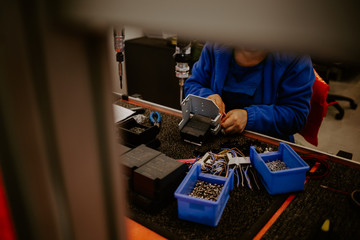 Close-up of hands of young computer engineer fixing broken pc parts at the desk in the home office