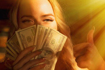 Beautiful woman with US Dollar bills making Ok gesture as if she want to say: Money really can buy You happiness.