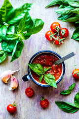 Homemade Red Italian Pizza Sauce with Tomato, Green Basil and Garlic on the Wooden Table Vertical Orientation
