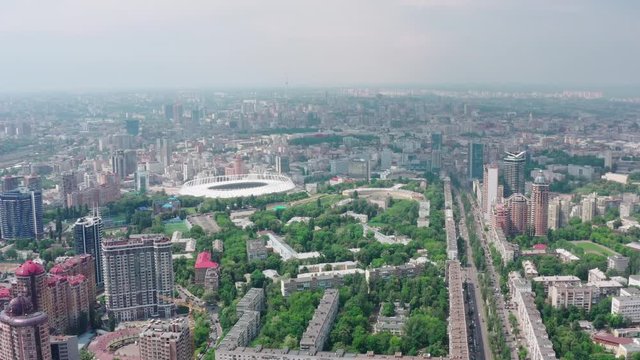 Stadium in a green city, a terrible sky and the sun's rays. Kyiv, Ukraine - Cityscape Aerial Flight