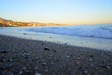 Malaga, Spain - March 4, 2020: Detail of small waves on the Malagueta Beach in Malaga.