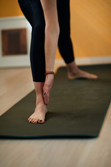 Closeup of middle aged brunette in Tripod Headstand yoga pose.