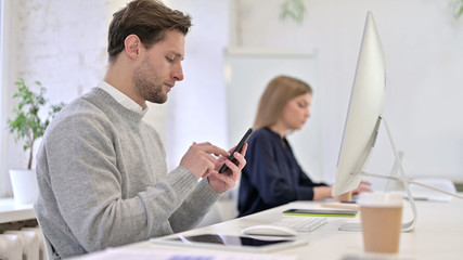 Obraz premium Serious Creative Professional Using Smartphone in Office