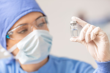 Female laboratory technician with ampoule of virus vaccine - obrazy, fototapety, plakaty