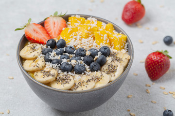 Healthy smoothie bowl with mango, strawberry, blueberry, banana, Chia seeds and granola. Healthy vegan diet food concept.