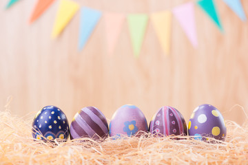 Happy Easter day colorful eggs on nest with blurred celebrate banner party flags with copy space