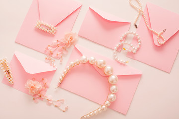 The wedding background with space for text, decorated with invitation envelopes and decorations for the bride, is made in soft pastel colors, with copy space. Conceptual backgrounds for wedding texts.