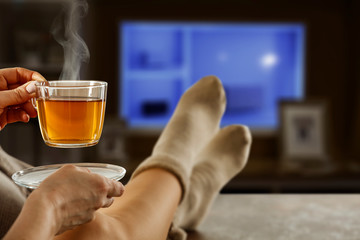 Female legs in socks on the table. Place for your product. Young woman undergoes quarantine due to coronavirus.