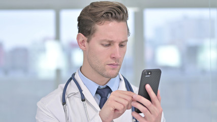 Portrait of Young Male Doctor using Smartphone in Office