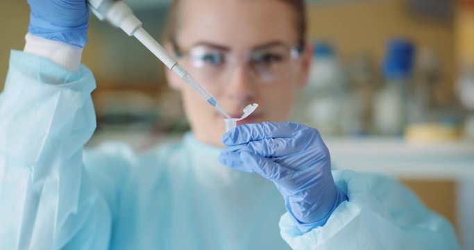 female scientist with a pipette analyzes a liquid at laboratory