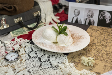 Icecream with chocolate powder and mint leafs on white plate