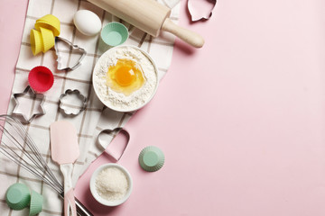 Baking utensils and ingredients.  Rolling pin, sugar sprinkling, whisk with cookie mold on a pink background. Baking concept. Place for text.