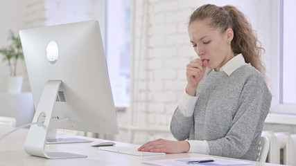 Sick Young Latin Woman Working on Desktop and Coughing