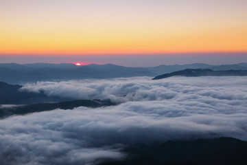 Fototapeta na wymiar Scenery of the sunrise at the high mountains. Dense fog with beautiful light. Location Carpathian mountain, Ukraine, Europe. Magic spring wallpaper.