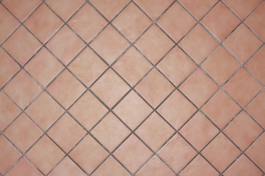 chapado o aplacado de azulejo de gres tipo terracota en colores tierra, colocado con junta perimetral de cemento gris y a cartabon