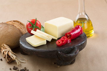 cheddar cheese on wooden plate with bread and oil