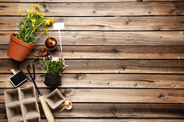 Garden rake with flowers on brown wooden table