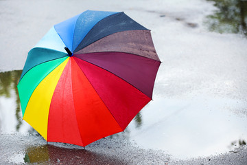 Colorful umbrella on asphalt after rain