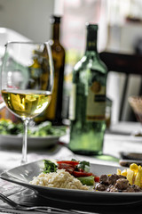 glass of red wine and bottle of white wine on wooden table