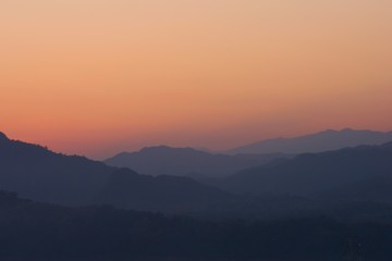 Twilight sky over hazy mountains. View from atop Mount Phou Si, in Luang Prabang, Laos.