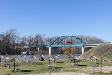 Beautiful sunny day on the river with large metal bridge