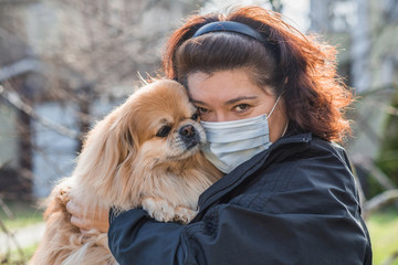 Virus concept. Mature woman in mask with his dog, risk for health and problem