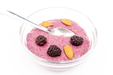 Smoothie made of blackberries in the bowl with almonds
