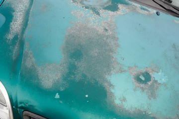 Peeling paint on grunge hood faded old car green used