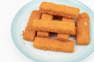 Fried fish sticks on the plate above white background