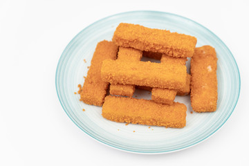 Fried fish sticks on the plate above white background