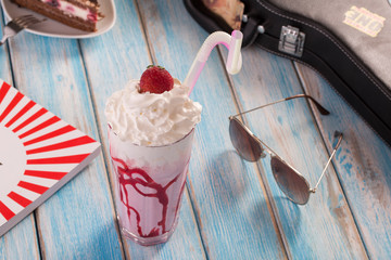 strawberry milkshake on blue wooden table in summer