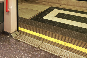 Opened doors of London underground tube  train with yellow line on ground