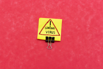 sticky note with warning coronavirus sign isolated on pink background