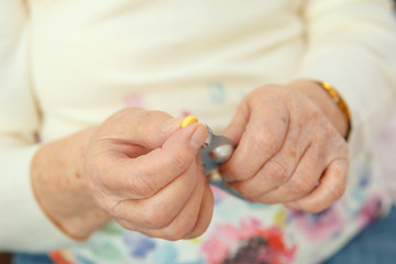 An elderly woman is going to swallow a medicine