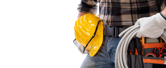 Electrician holds the roll of electric cable in his hand, helmet with protective goggles. Construction industry, electrical system. Isolated on a white background.