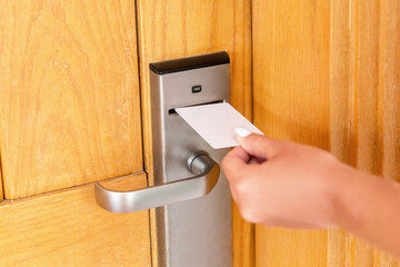 Woman hand with keycard in the electronic lock. female hand hold key card and open electronic lock...