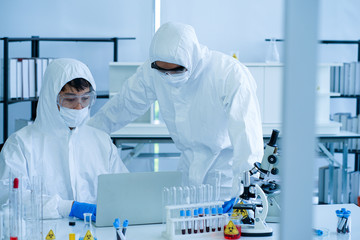 Naklejka premium The COVID-19 warning sign on the glass of the clinical laboratory in hospital with the defocused blurred background of medical doctor scientists were doing research for VIRUS prevention and cure 