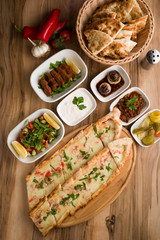 turkish cheese pide with garnitures on wooden table
