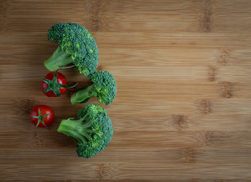 Broccoli and  tomatoes  on wooden board, high resolution photo
