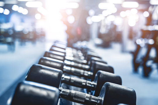 rows with a set of dumbbells in modern light gym