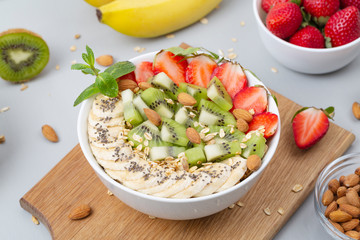 Smoothie bowl with banana, strawberry, almond, Chia seeds, kiwi and granola. Delicious healthy Breakfast
