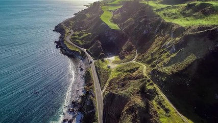 Northern Ireland, UK, Atlantic coast with cliffs. Causeway Coastal Route a.k.a Antrim Coast Road a.k.a. One of the most scenic coastal roads in Europe. Aerial 4K video. Winter, sunrise ligh