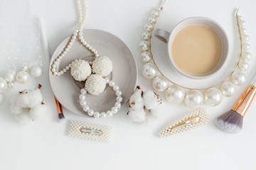Jewelry for the bride, pearls, makeup brushes, delicate colors, candy and coffee, on a white background. Conceptual photography for weddings, preparation and morning of the bride.