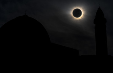 Solar eclipse over a mosque