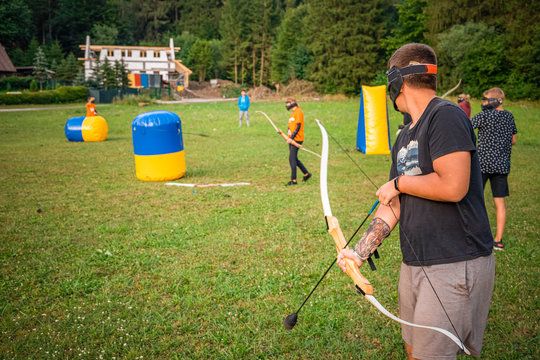 Young man preparing for an attack while playing archery tag