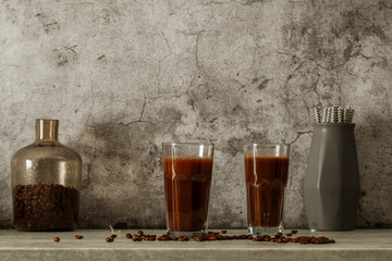 Iced coffee with milk on a dark background. Coffee with ice and cream on a gray background close-up.